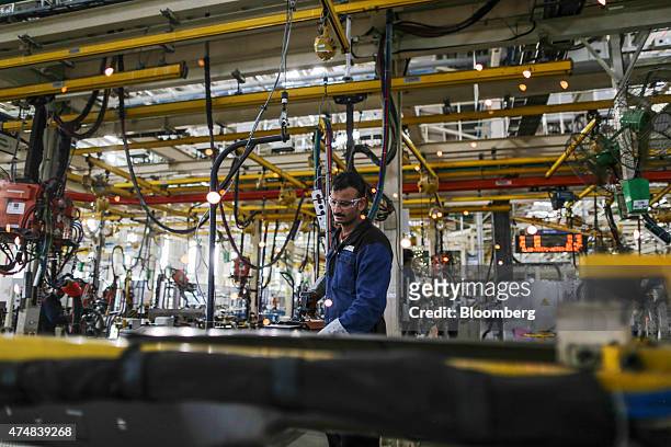 An employee operates vehicle body welding machinery on the BharatBenz truck production line of the Daimler India Commercial Vehicles Pvt....
