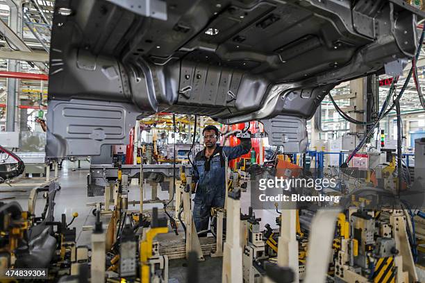 An employee operates a hoist crane on the BharatBenz truck production line of the Daimler India Commercial Vehicles Pvt. Manufacturing plant in...