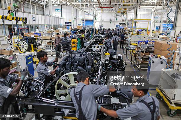 Employees work on the chassis and powertrain of a BharatBenz truck on the production line of the Daimler India Commercial Vehicles Pvt. Manufacturing...