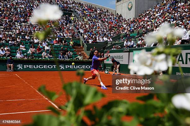 Roger Federer of Switzerland plays a backhand in his Men's Singles match against Marcel Granollers of Spain during day four of the 2015 French Open...