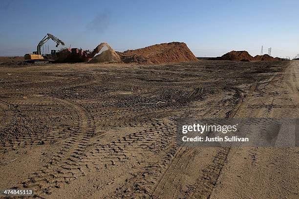 Workers shred uprooted almond trees at Baker Farming on February 25, 2014 in Firebaugh, California. Almond farmer Barry Baker of Baker Farming had...