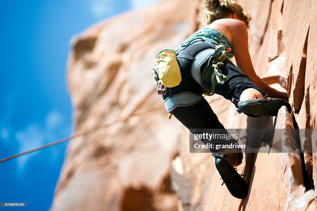 Junge Frau, die eine Sandstein Felsen klettern in Moab Utah