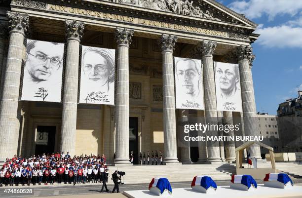 People stand in front of the Pantheon where drawings representing French politician Jean Zay, French resistant Genevieve de Gaulle-Anthonioz, French...