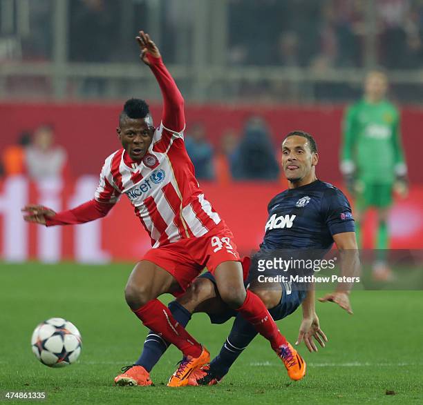 Rio Ferdinand of Manchester United in action with Michael Olaitan of Olympiacos FC during the UEFA Champions League Round of 16 match between...