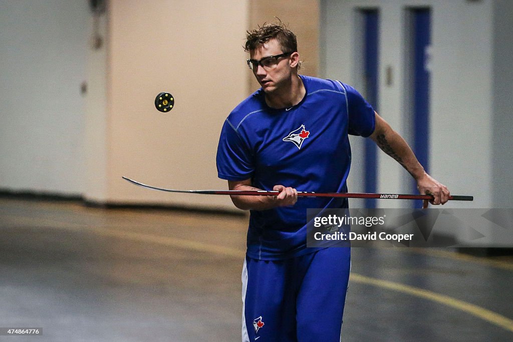 Brett Cecil (27) of the Toronto Blue Jays plays street hockey with Liam Hendriks (31) and Josh Thole (22)