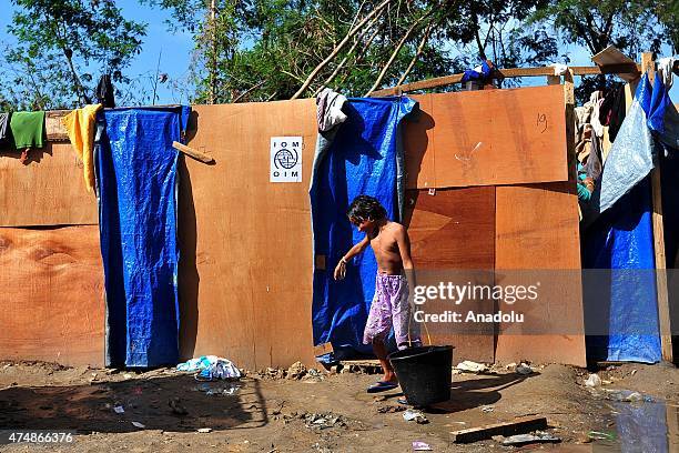 Rohingya refugee child carries a bucket of water at a temporary shelter as they cook food at Kuala Langsa, Aceh province, in Indonesia, on May 27,...