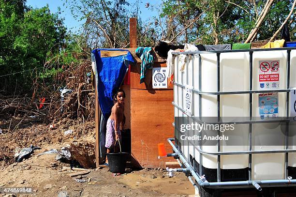 Rohingya refugee child carries a bucket of water at a temporary shelter as they cook food at Kuala Langsa, Aceh province, in Indonesia, on May 27,...