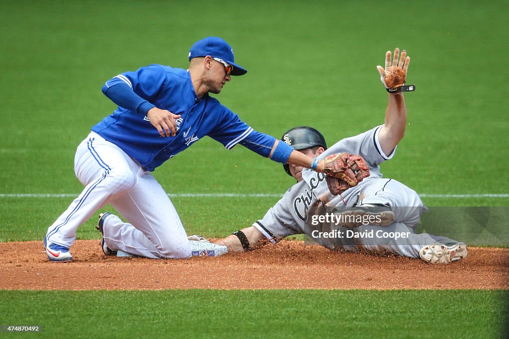 J.B. Shuck (20) of the Chicago White Sox was called out on the field as Ryan Goins (17) of the Toronto Blue Jays tries to apply the tag, but was ruled safe after a review