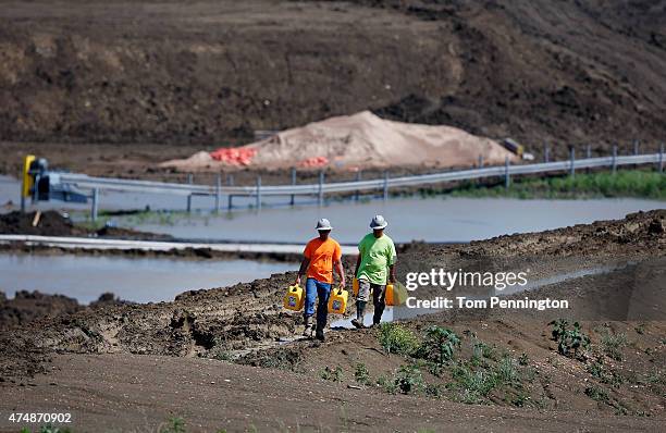 Workers tend to equipment used to pump water from Padera Lake on May 27, 2015 in Midlothian, Texas. Officials feared that the temporary dam on Padera...