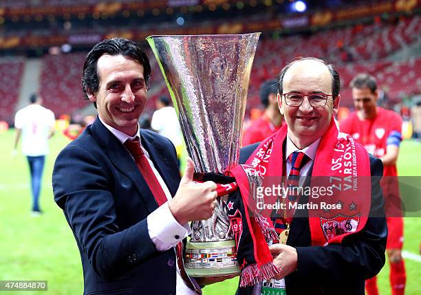 Unai Emery , coach of Sevilla poses with Sevilla President Jose Castro and the trophy after the UEFA Europa League Final match between FC Dnipro...