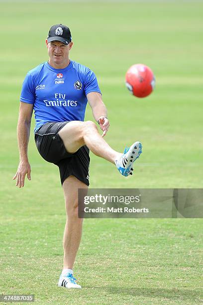 Magpies coach Nathan Buckley kicks the ball during a Collingwood Magpies AFL training session at the Southport Football Club on February 26, 2014 on...