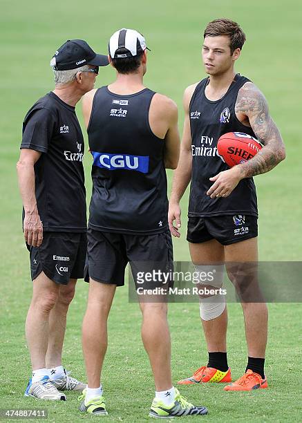 Jamie Elliott speaks with coaching staff during a Collingwood Magpies AFL training session at the Southport Football Club on February 26, 2014 on the...