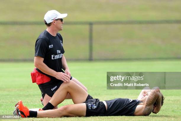 Jamie Elliott recieves attention on the field during a Collingwood Magpies AFL training session at the Southport Football Club on February 26, 2014...