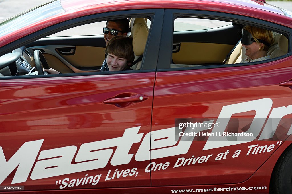 Blind people get a chance to drive cars and feel what it is like to be behind the wheel of a car at The MasterDrive Experience in Centennial, Colorado.