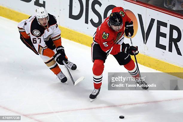 David Rundblad of the Chicago Blackhawks skates with the puck as Rickard Rakell of the Anaheim Ducks defends in Game Six of the Western Conference...