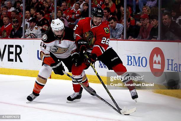 Kyle Cumiskey of the Chicago Blackhawks skates with the puck in the first period as Nate Thompson of the Anaheim Ducks defends in Game Six of the...