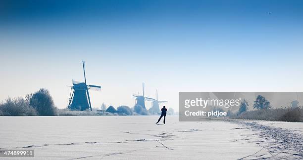 ice-skating man on canal,near windmills kinderdijk winter time - ice skate 個照片及圖片檔