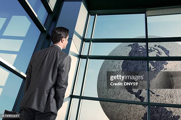 businessman in airport contemplating world travel - better world stockfoto's en -beelden