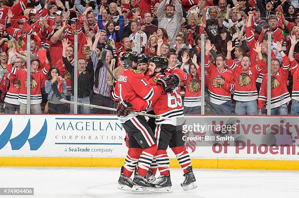 Andrew Shaw of the Chicago Blackhawks celebrates with teammates, including Marcus Kruger, after scoring an empty-net goal against the Anaheim Ducks...