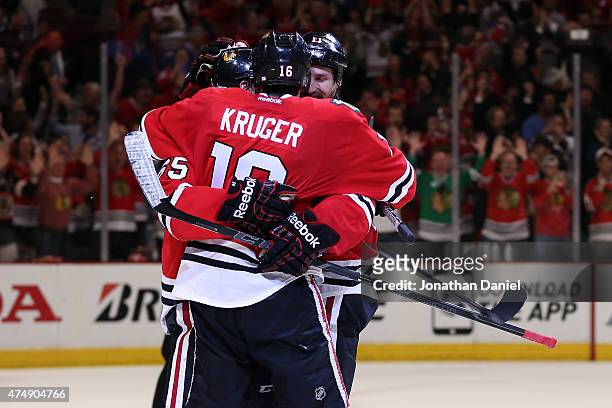 Andrew Shaw celebrates with Andrew Desjardins and Marcus Kruger of the Chicago Blackhawks against the Anaheim Ducks in Game Six of the Western...