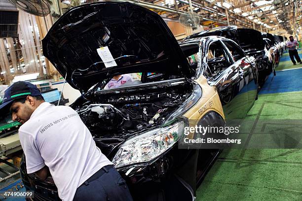 An employee of Indus Motor Co., the Pakistan affiliate of Toyota Motor Corp., works on the Toyota Corolla production line of the company's plant in...