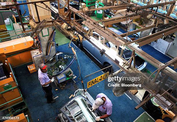 Employees of Indus Motor Co., the Pakistan affiliate of Toyota Motor Corp., work on the Toyota Corolla production line of the company's plant in...
