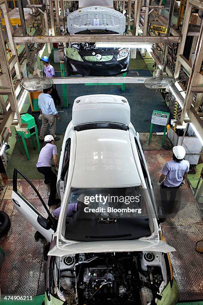 Employees of Indus Motor Co., the Pakistan affiliate of Toyota Motor Corp., work on the Toyota Corolla production line of the company's plant in...