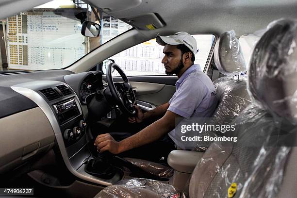 An employee of Indus Motor Co., the Pakistan affiliate of Toyota Motor Corp., makes a final inspection of a Toyota Corolla GLi automobile assembled...