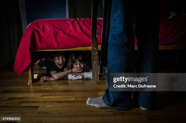 two kids hidden under bed crying out of fear - mean dad stock pictures, royalty-free photos & images