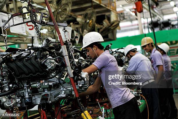 Employees of Indus Motor Co., the Pakistan affiliate of Toyota Motor Corp., assemble Toyota Corolla engines at the company's plant in Karachi,...