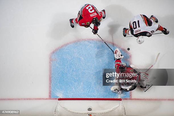 Goalie Corey Crawford of the Chicago Blackhawks gets in position to stop the puck, as Duncan Keith and Corey Perry of the Anaheim Ducks reach in, in...