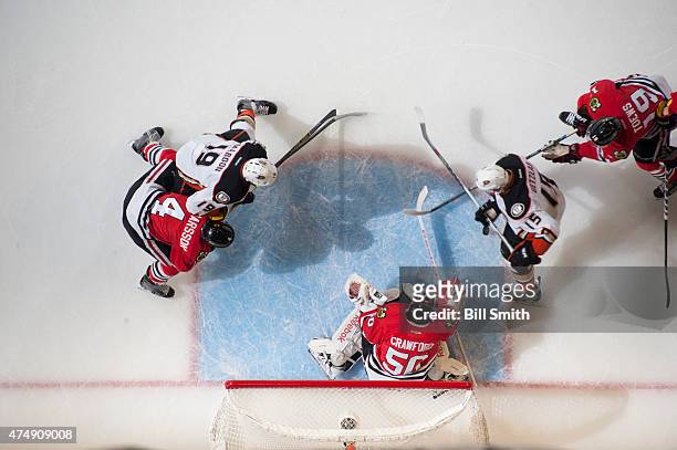 Goalie Corey Crawford of the Chicago Blackhawks guards the net as Ryan Getzlaf of the Anaheim Ducks and Jonathan Toews chase the puck in Game Six of...