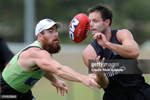 Nathan Brown handballs in the tackle of Ben Hudson during a Collingwood Magpies AFL training session at the Southport Football Club on February 26,...