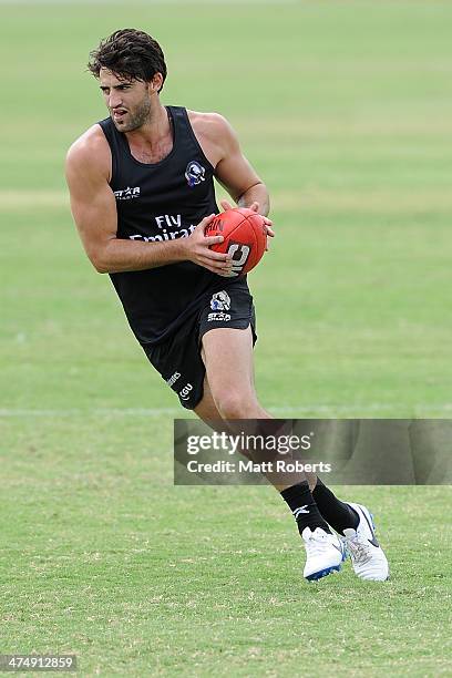 Alex Fasolo runs with the ball during a Collingwood Magpies AFL training session at the Southport Football Club on February 26, 2014 on the Gold...