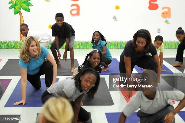 Jenna Bush Hager and First Lady Michelle Obama participate in a yoga class during a visit to the Gwen Cherry Park NFL/YET Center as she celebrates...