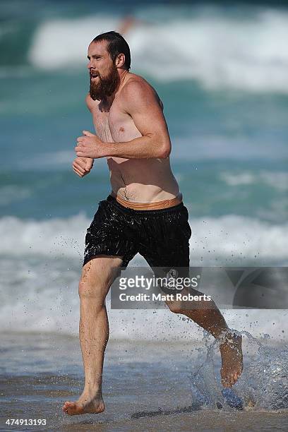 Ben Hudson runs out of the water during a Collingwood Magpies AFL beach session at the Southport Spit on February 26, 2014 on the Gold Coast,...