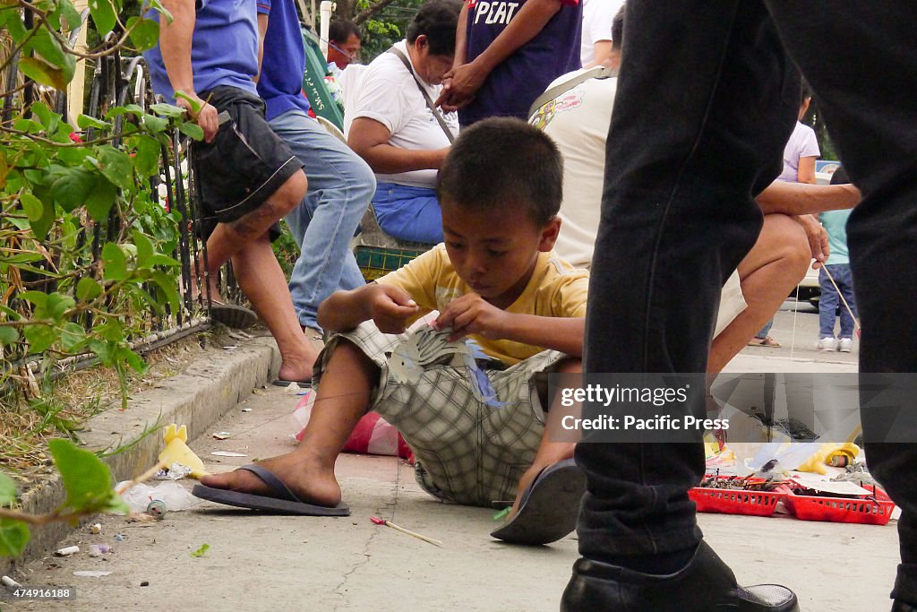 A young boy stirring something in his hand at the sidewalk...