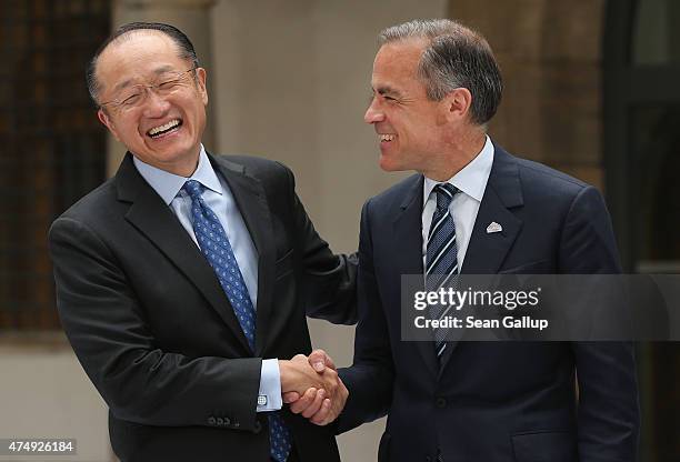 President of the World Bank Group Jim Yong Kim and Governor of the Bank of England Mark Carney chat prior to the group photo of finance ministers,...