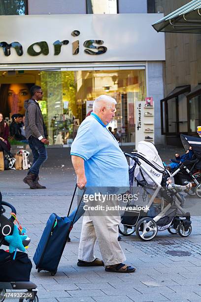 caucasian senior man with shopping trolley in essen - senior essen stockfoto's en -beelden