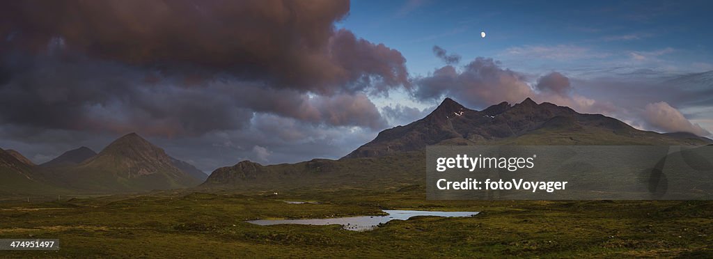 Moon rising over epic mountain landscape stormy sunset panorama Scotland
