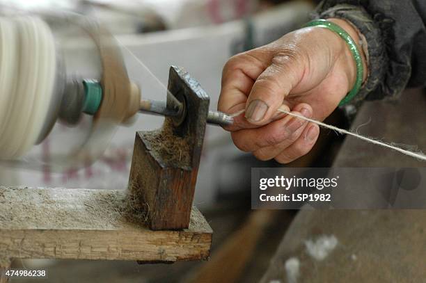 nahaufnahme der hand-wolle gesponnen werden.   hand spinning-wolle. - sweatshop stock-fotos und bilder