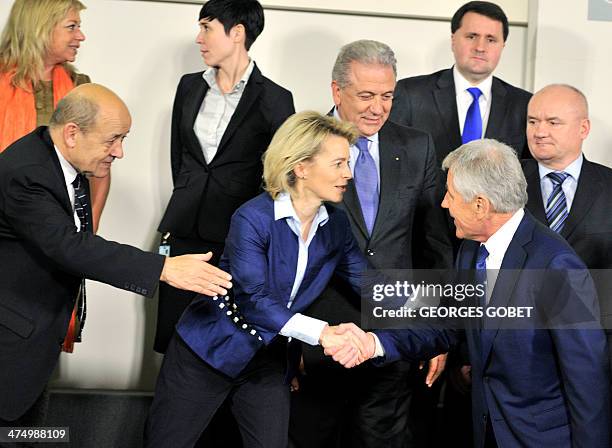 French minister of Defence Jean-Yves Le Drian gestures as US secretary of defense Chuck Hagel shakes hands with German Defence minister Ursula Von...