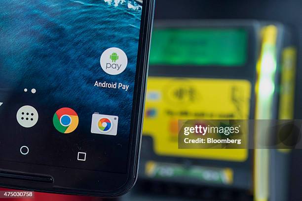 An attendee displays Google Inc. Android Pay icon on a mobile device for a photograph during the Google I/O Annual Developers Conference in San...