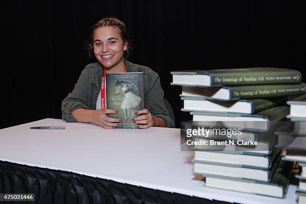 Author Paige McKenzie poses for photographs with her newest book during BookExpo America held at the Javits Center on May 28, 2015 in New York City.