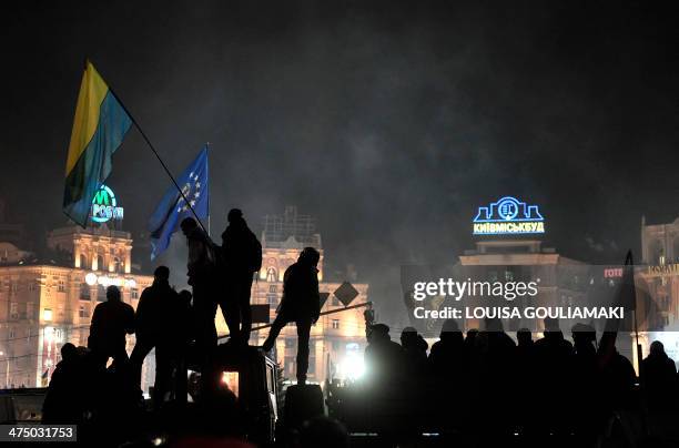 People stand on a truck as thousands gather in Kiev's Independence square to hear the line-up of the new pro-Western cabinet on February 26, 2014....