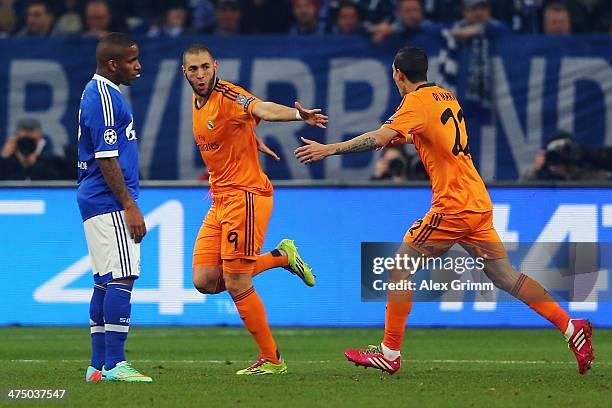 Karim Benzema of Madrid celebrates his team's first goal with team mate Angel Di Maria as Jefferson Farfan of Schalke reacts during the UEFA...