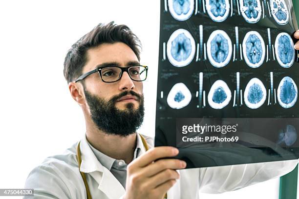 hipster médico examinar las radiografías del cerebro - cervix fotografías e imágenes de stock