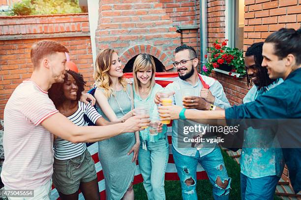 happy young people toasting at backyard party. - fourth of july party stock pictures, royalty-free photos & images