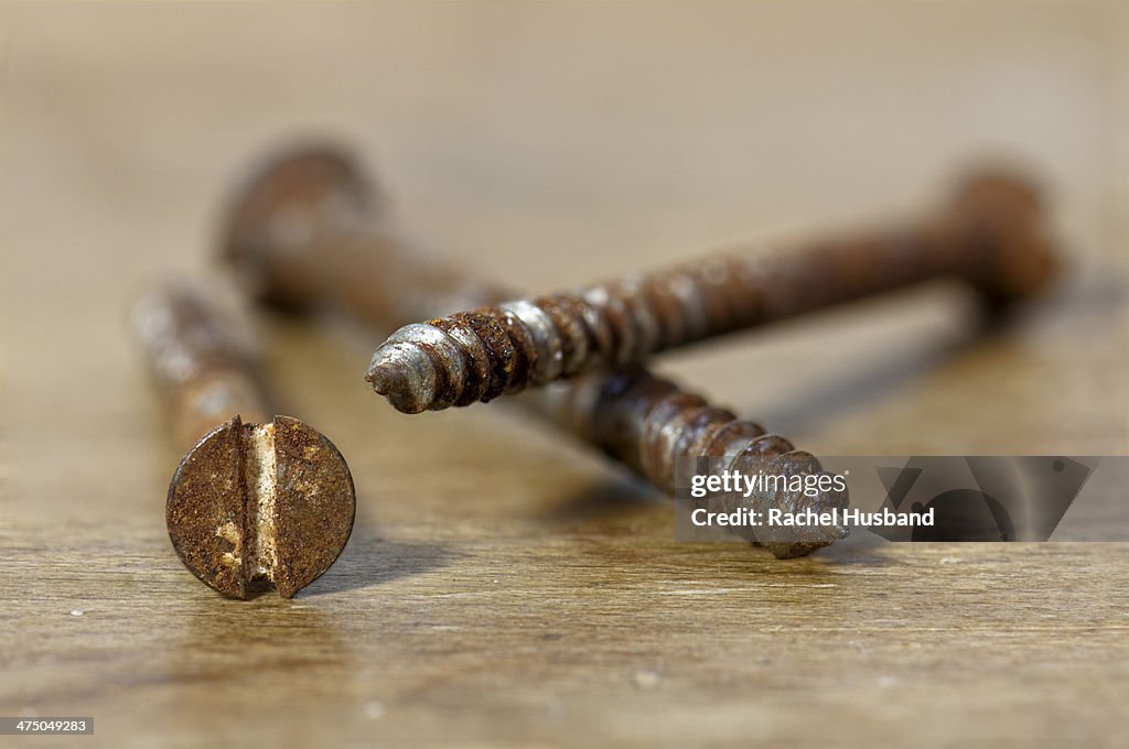 Rusty screws on wooden worktop
