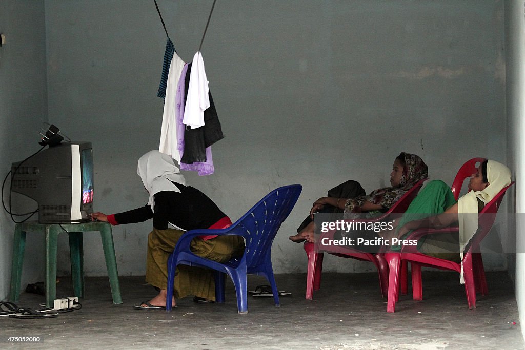 Myanmar Rohingya migrant women watch television on the...